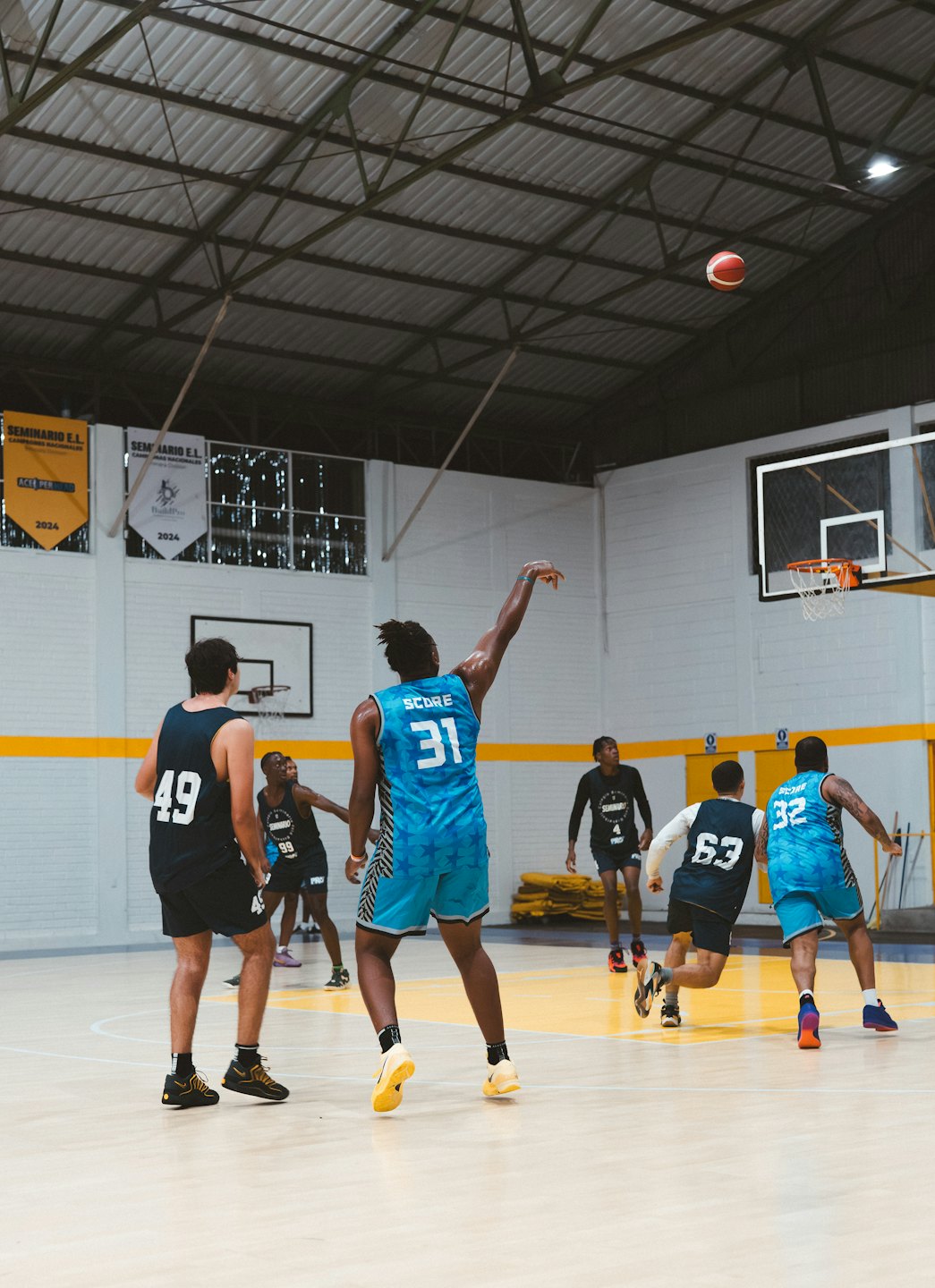 Basketball player in a blue jersey shoots toward the hoop.