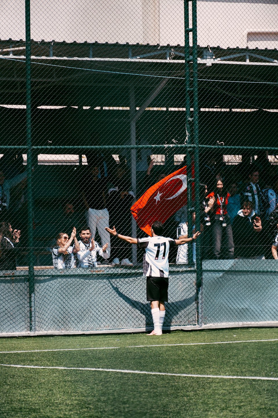 Soccer player in striped jersey celebrates before cheering fans.
